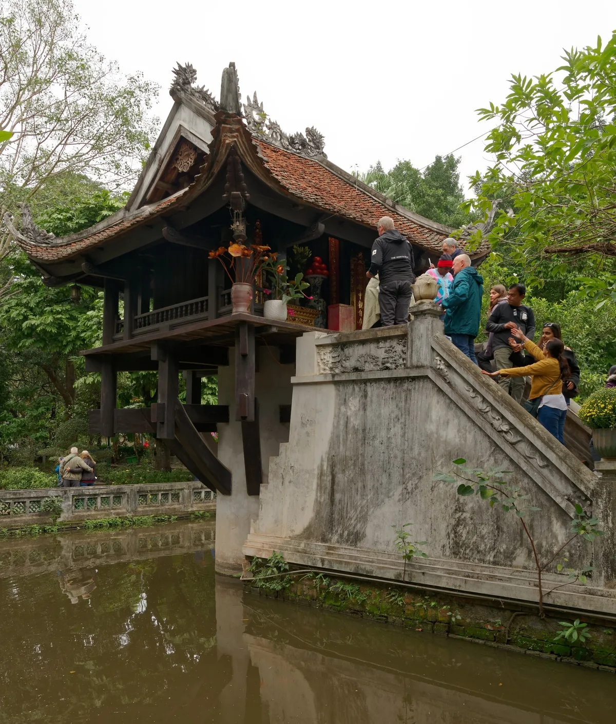 Du khách leo cầu thang đá lên chùa Một Cột bằng gỗ nổi trên hồ sen ở Hà Nội.